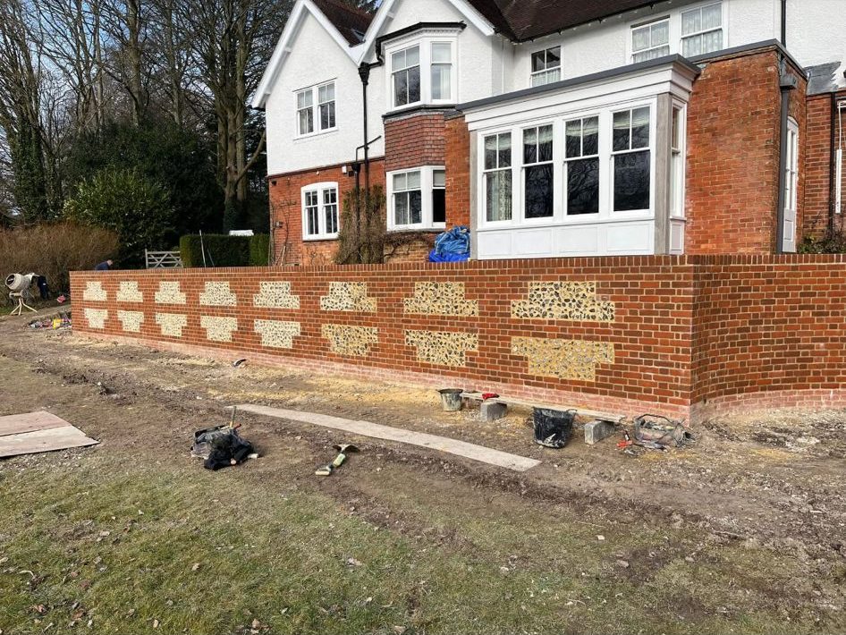 Flint and brick garden wall under construction in Hampshire by Green's Brickwork
